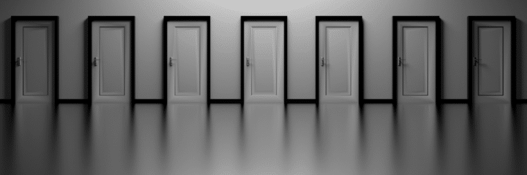 A white room with seven closed doors positioned next to each other.